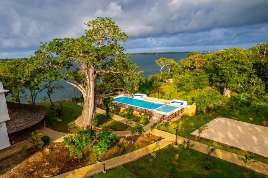 Aerial view of Kasa Pomboo's clifftop pool and baobab tree overlooking the Wasini Channel