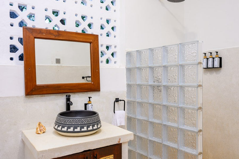 Bathroom with vessel sink and glass-block shower in a Kasa Pomboo guest room